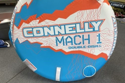Round inflatable tube with 'Connelly Mach 1 Double Disk' design in blue, orange, and white.